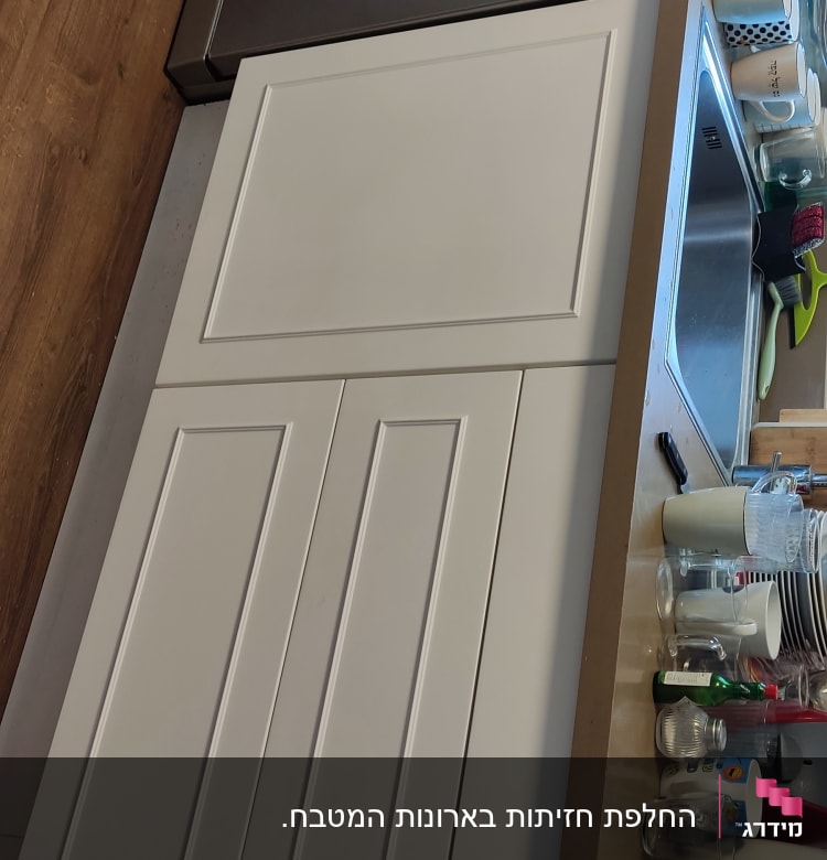 ארונות מטבח לבנים, כיור נירוסטה, כלים על השיש